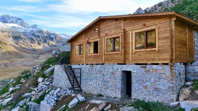 Dağ manzarasında taş temelli ahşap yayla evi